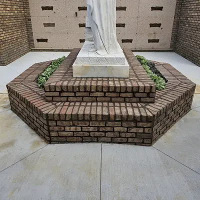 Coursed brick base and steps at a memorial courtyard.