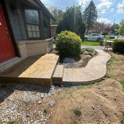 A stamped and colored concrete walkway and step at a front entrance.