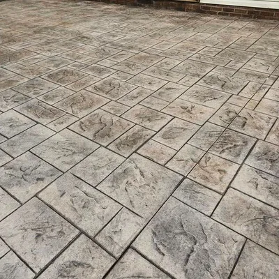 A close-up of an ashlar-pattern stamped concrete patio surface.