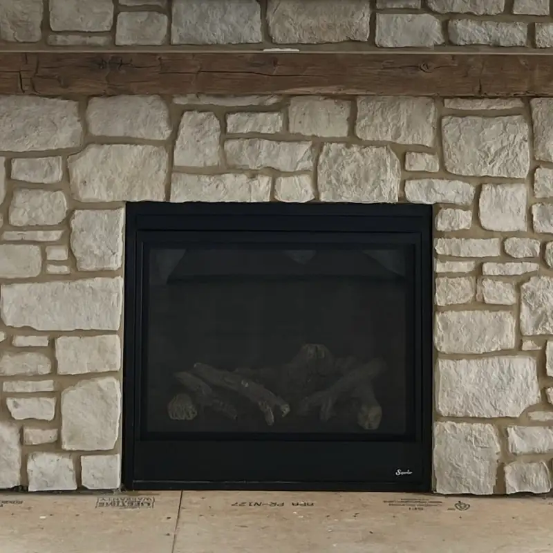 A coursed stone fireplace surround with a timber mantel, built for a family home.